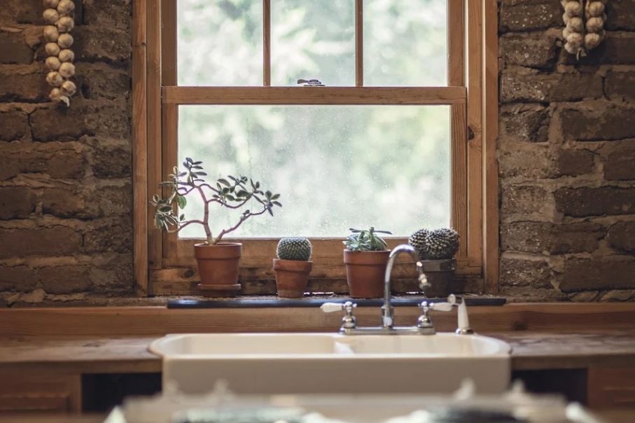 Picture of a brick wall featuring a window and a farmhouse sink.
