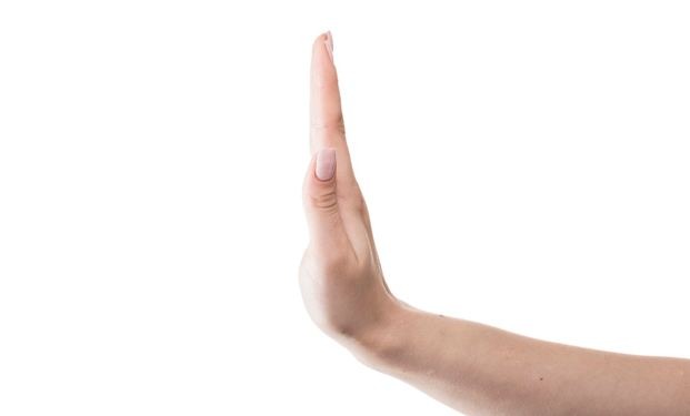 An image with a hand gesturing the stop sign.