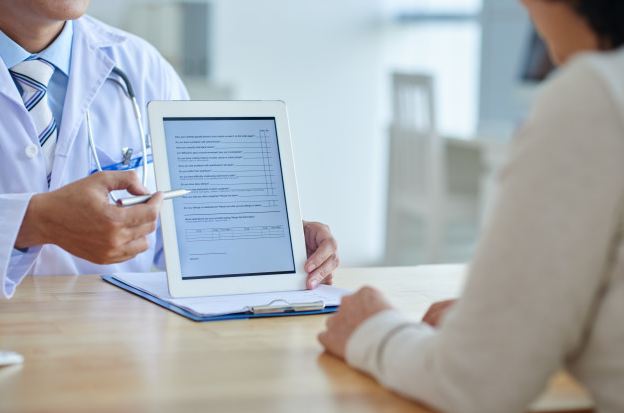 doctor showing digital record to patient on tablet