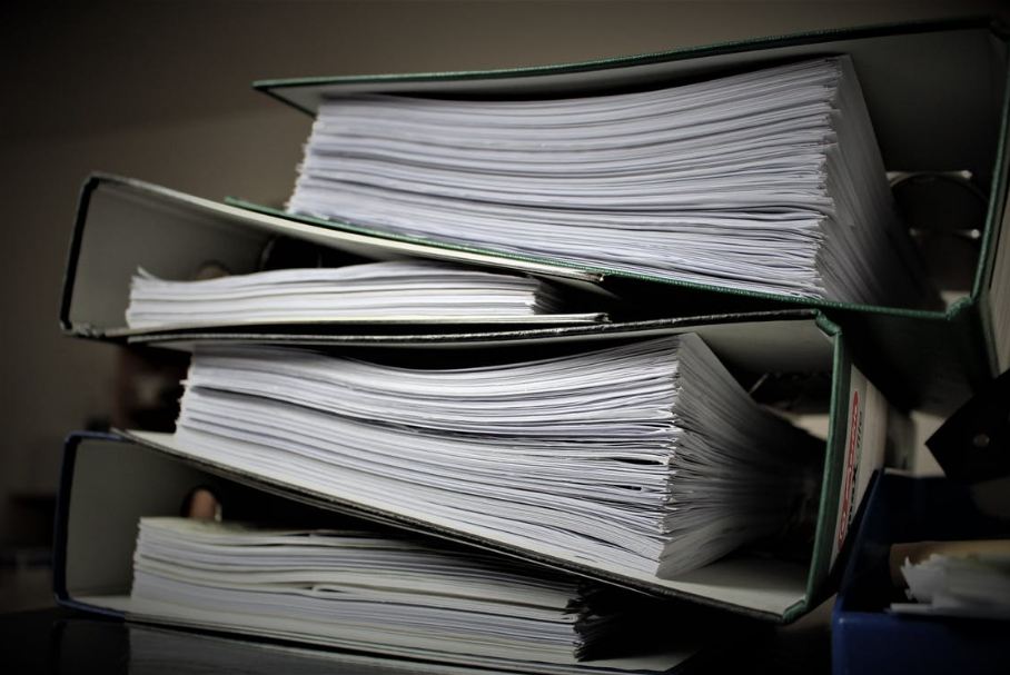 three ring binders with documents piled up on each other