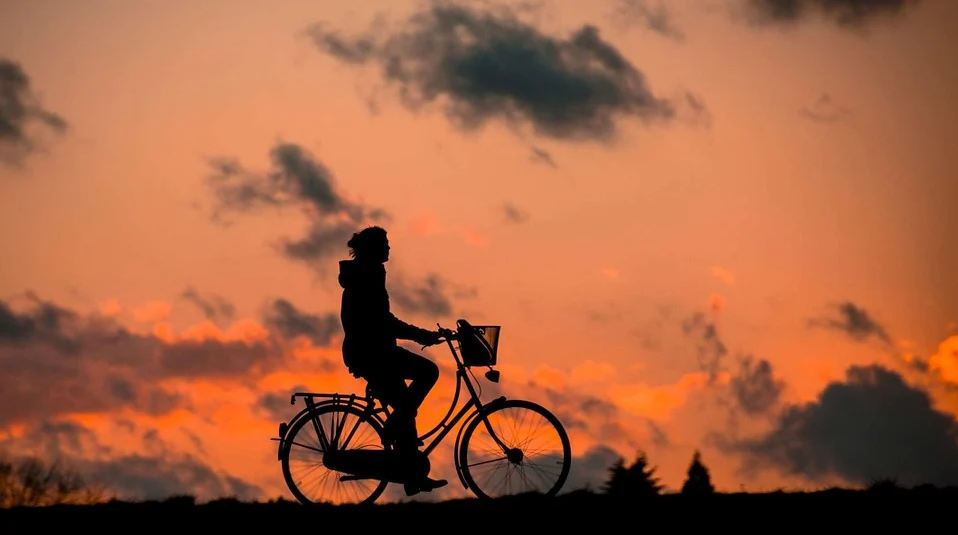 An image with a silhouette of a person cycling.