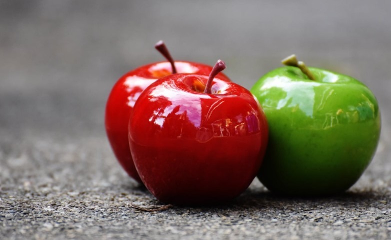 two red apples place with a green one