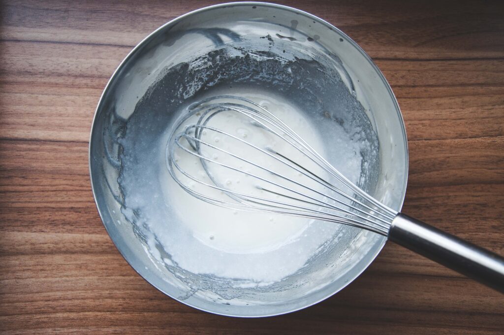 hand whisk in a mixing bowl image