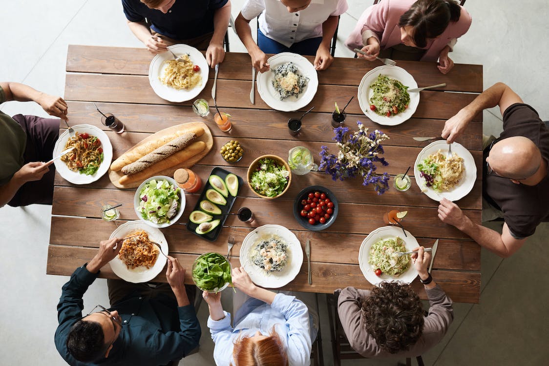 a group of people having a meal on a wooden table