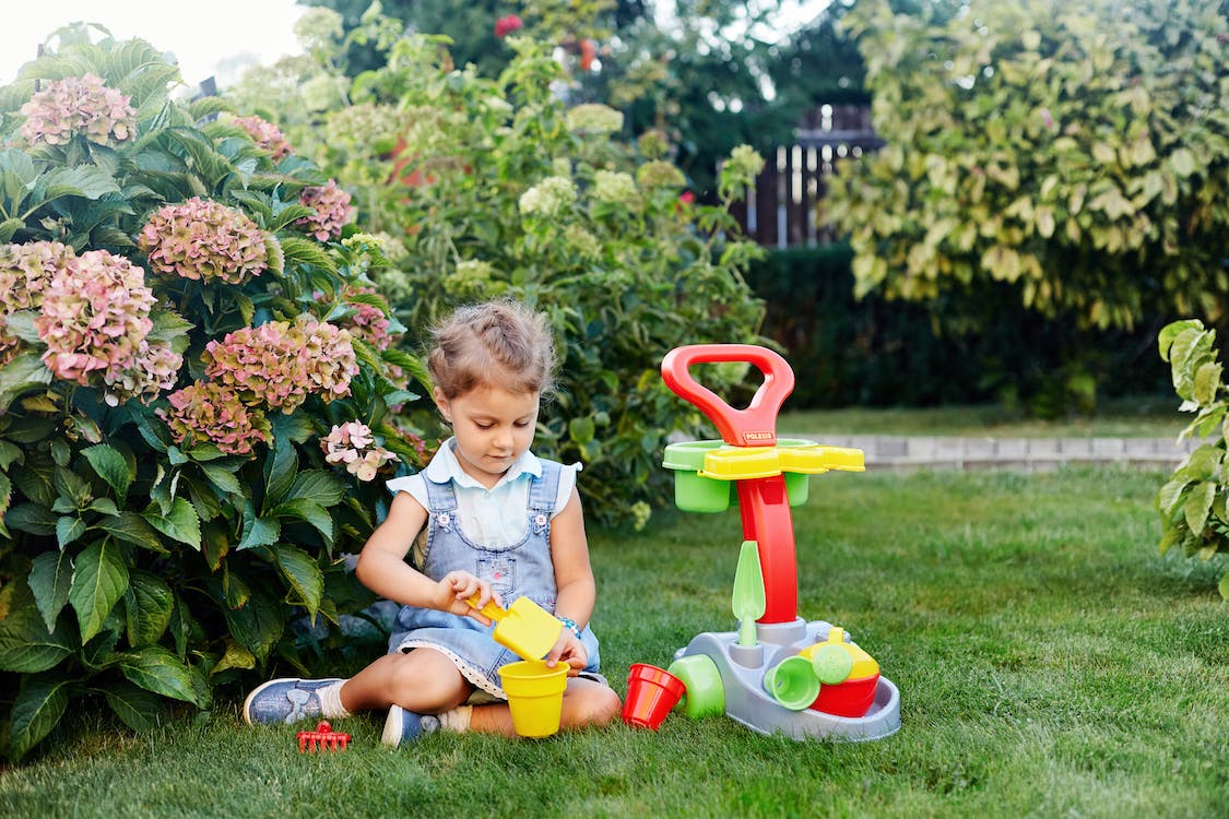 little girl playing with gardening toys